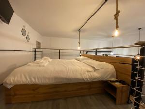 ein Schlafzimmer mit einem Bett mit einem Kopfteil aus Holz in der Unterkunft Avantgard Rooms Loft Maggiore in Bologna