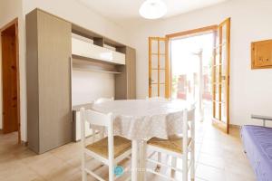 a dining room with a white table and chairs at Orsetta Flat - Torre Dell'Orso in Torre dell'Orso