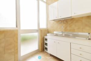a kitchen with white cabinets and a sink and a window at Orsetta Flat - Torre Dell'Orso in Torre dell'Orso