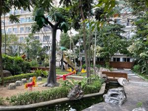 a park with a playground in front of a building at Homey 1BR Acqua Livingstone with Netflix, Pool & Gym in Manila