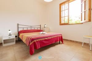 a bedroom with a bed with a red blanket and a window at Orsetta Flat - Torre Dell'Orso in Torre dell'Orso