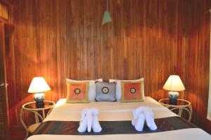 a bedroom with a bed with two slippers on it at Tamarind Lodge in Mae Nam
