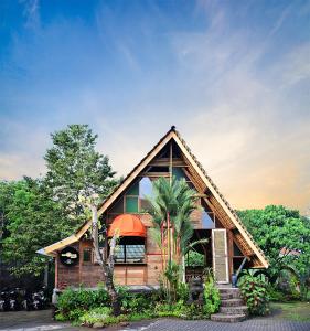 ein Haus mit einer Palme davor in der Unterkunft Kebun Hanoman Villa in Pablengan