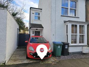 a small red car parked in front of a house at MAGICAL HARRY POTTER HOME IN WATFORD with FREE off-street PARKING in Watford