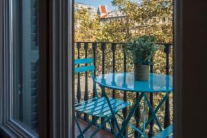 a blue table and chair on a balcony at Bcn Paseo De Gracia Rocamora Apartment in Barcelona