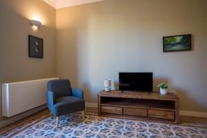 a living room with a blue chair and a television at Bcn Paseo De Gracia Rocamora Apartment in Barcelona