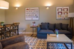 a living room with a blue couch and a table at Bcn Paseo De Gracia Rocamora Apartment in Barcelona