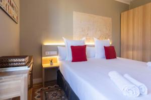 a bedroom with a large white bed with red pillows at Bcn Paseo De Gracia Rocamora Apartment in Barcelona