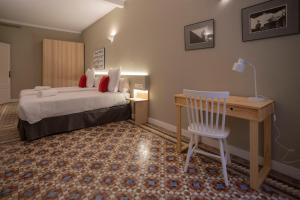 a bedroom with a bed and a desk and a chair at Bcn Paseo De Gracia Rocamora Apartment in Barcelona