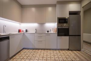a large kitchen with white cabinets and appliances at Bcn Paseo De Gracia Rocamora Apartment in Barcelona