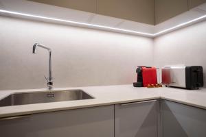a kitchen with a sink and a red appliance at Bcn Paseo De Gracia Rocamora Apartment in Barcelona