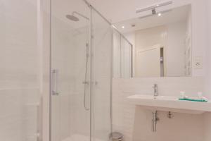 a bathroom with a glass shower and a sink at Bcn Paseo De Gracia Rocamora Apartment in Barcelona
