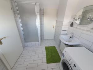 a white bathroom with a sink and a washing machine at Neumühler Hof- Ferienwohnung "Thomas" 3 Zimmer,3 Bäder mit Dusche, kostenfreie Parkplätze vor dem Haus in Schwerin +37 photos