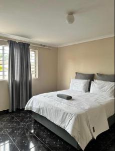 a bedroom with a large white bed with a window at Wood Road Apartments in Durban
