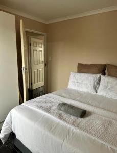 a bedroom with a large white bed with a pillow on it at Wood Road Apartments in Durban