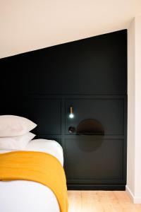 a black headboard of a bed in a room at Le Splendide de Poincaré in Nancy