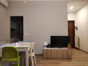 a living room with a table and a television at CasaTelù - a due passi dal centro storico in Cernusco sul Naviglio