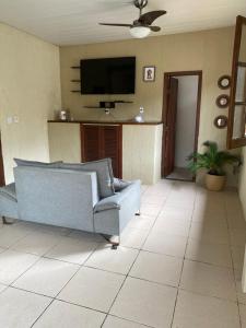 a living room with a couch and a flat screen tv at Casa com piscina in Armacao dos Buzios