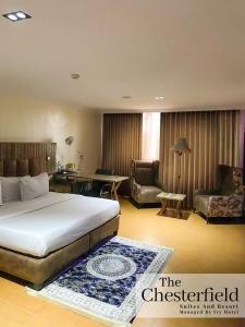 ein Hotelzimmer mit einem Bett, einem Schreibtisch und Stühlen in der Unterkunft The Chesterfield Hotel in Lagos