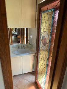 uma casa de banho com um lavatório e uma porta de vidro em Into the wild em Oira