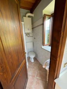 uma casa de banho com um WC e uma porta de madeira em Into the wild em Oira