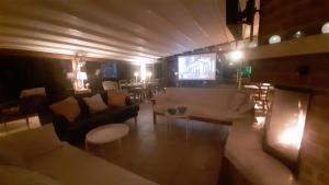 a living room with a couch and a tv at Swiss Eviniz Hotel in Adrasan