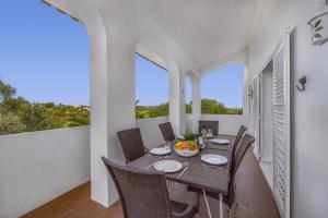 a dining room with a table and chairs on a balcony at Villa Alfarrobeira by Villa Plus in Lagoa