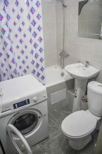 W łazience znajduje się pralka i umywalka. w obiekcie NBG Flat w mieście Ałma-Ata