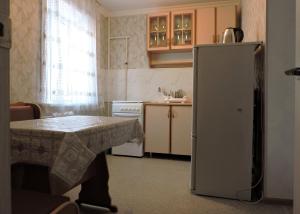a kitchen with a table and a refrigerator at NBG Flat in Almaty