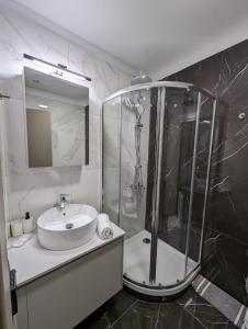 een badkamer met een glazen douche en een wastafel bij B1 Urban Studio in Larisa