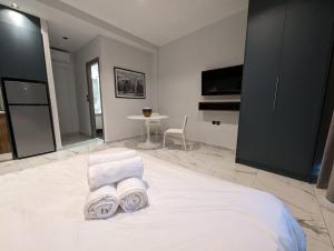 een slaapkamer met een bed met handdoeken en een tafel bij B1 Urban Studio in Larisa