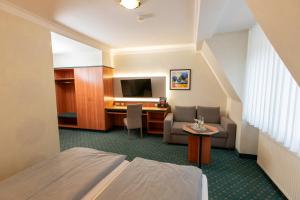 a hotel room with a bed and a desk at Hotel Gasthof Gose in Ziegenhagen