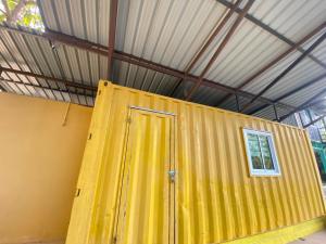 ein gelber Behälter mit einer Tür in einem Raum in der Unterkunft แอนฟาร์มรีสอร์ทแอนด์คาเฟ่ลำปาง 
