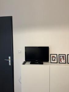 a flat screen tv sitting on top of a white cabinet at Appartement au centre-ville à 100 m des télécabines avec parking souterrain gratuit in Luchon