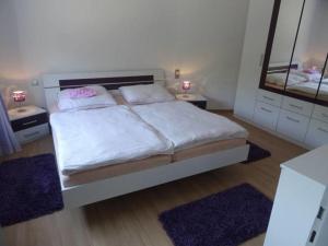 a bedroom with a bed with two mirrors and two rugs at Ferienwohnung "Udri" in Oberwürzbach