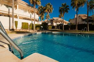 Bazén v ubytovaní Front line beach townhouse with sea views and south facing, in Costabella, Marbella alebo v jeho blízkosti