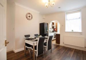 cocina y comedor con mesa y sillas en 4 Bedroom Apartment with non-smoking room - Good for family & business en Lincolnshire