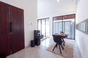 a living room with a table in a room with windows at The Lavana De Mello's Villa Seminyak -1 Bedroom Villa with Private Pool in Kerobokan