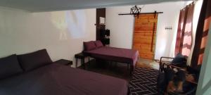 a room with a bed and a couch and a door at La Minimalista in Bagac
