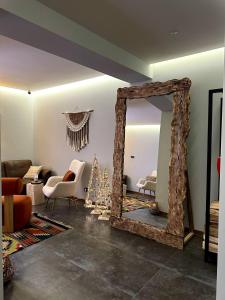 een woonkamer met een spiegel en een kerstboom bij AINO Hotel in Pilipets