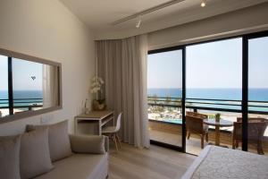 a living room with a couch and a view of the ocean at Venus Beach Hotel in Paphos