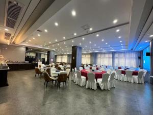 um salão de banquetes com mesas e cadeiras numa sala em Jiayu Hotel - Guangzhou Baiyun International Airport T2 Terminal em Huadu