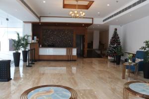 een lobby met een kerstboom in het midden bij Hotel Seven Lights in Ernakulam