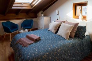 1 dormitorio con 1 cama grande con sábanas y almohadas azules en Hostal Pension Artilleiro, en Santiago de Compostela