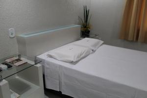 索布拉爾的住宿－Hotel Visconde，一间医院间,配有一张白色的床和一张桌子