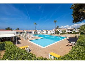 a swimming pool with chairs and a resort at Appartamento Melissa - Son Bou in Son Bou