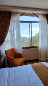 a bedroom with a chair and a large window at Unit 551,Privately Owned, Superior Room At the Forest Lodge Camp John Hay, Mountain View, 2 Double Beds in Baguio