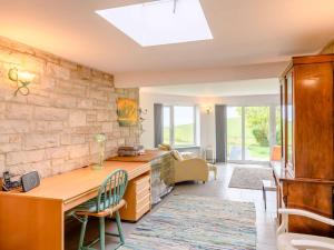 a home office with a wooden desk and a stone wall at 3 Bed in Worth Matravers DC140 in Worth Matravers