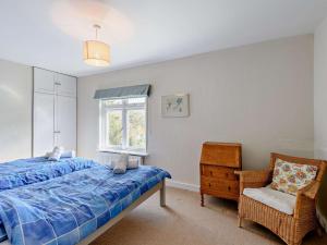 a bedroom with a bed and a chair and a window at 4 Bed in West Holme DC204 in East Stoke