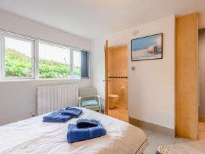 a bedroom with a bed with two blue towels on it at 3 Bed in Worth Matravers DC140 in Worth Matravers